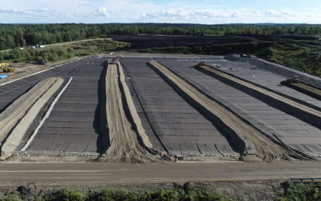 Aerial view of a rectangular landfill with covered waste rows.