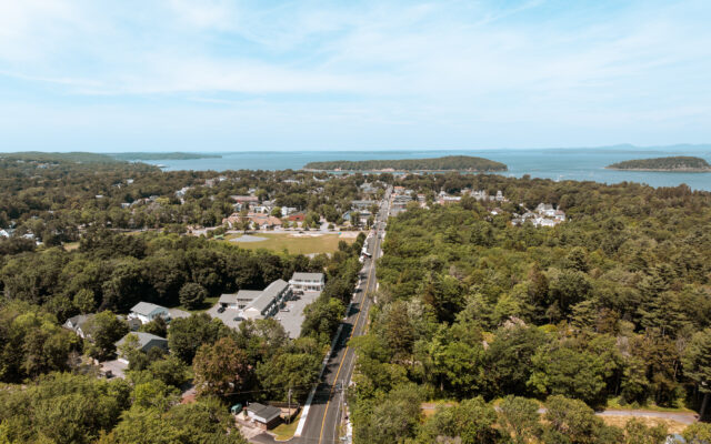 Town main road through trees toward water and islands.