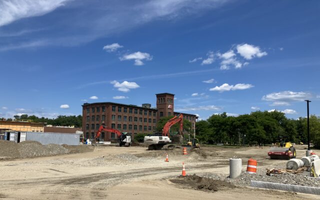 Excavators and cones at brick building construction site.