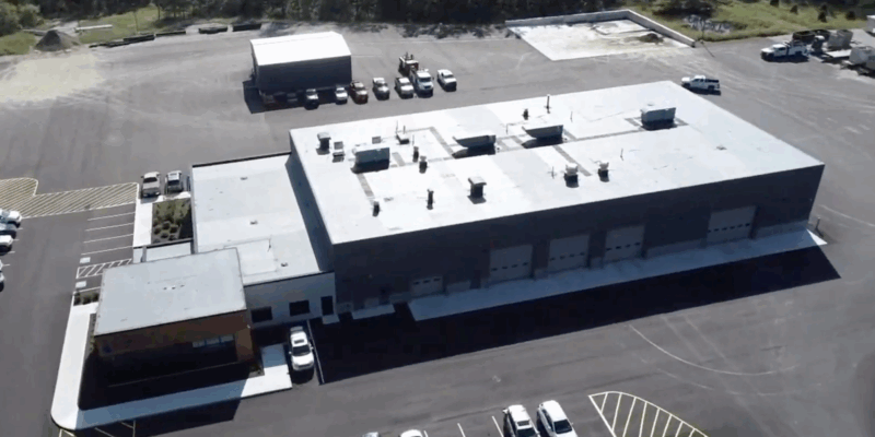 Aerial view of a large industrial building with garage bays.